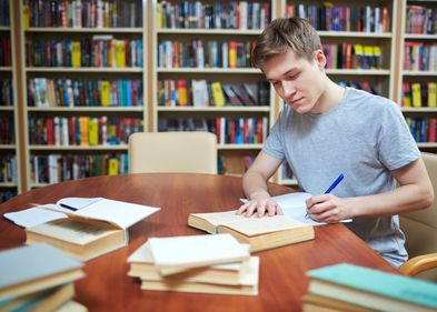 Studierender recherchiert für eine Forschungsarbeit in der Bibliothek. Foto: Colourbox.