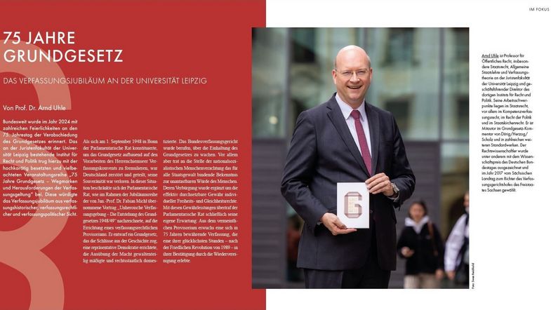 Ausschnitt des Berichts im Jahresmagazin: linke Hälfte mit weißer Schrift auf rotem Grund als Überschrift "75 JAHRE GRUNDGESETZ", darunter die erste Seite des Beitrags, am linken Rand ein großes dekoratives Paragrafenzeichen; in der rechten Hälfte Foto von Prof. Uhle, der ein Grundgesetz lächelnd in die Kamera hält; am rechten Rand auf weißem Grund ein kurzer Vorstellungstext zu Prof. Uhle; Bild: Universität Leipzig