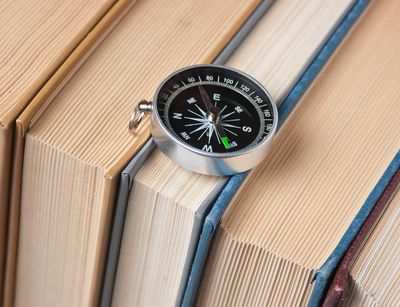 Das Bild zeigt einen Kompass, der auf einer Reihe von Büchern liegt, Foto: Colourbox