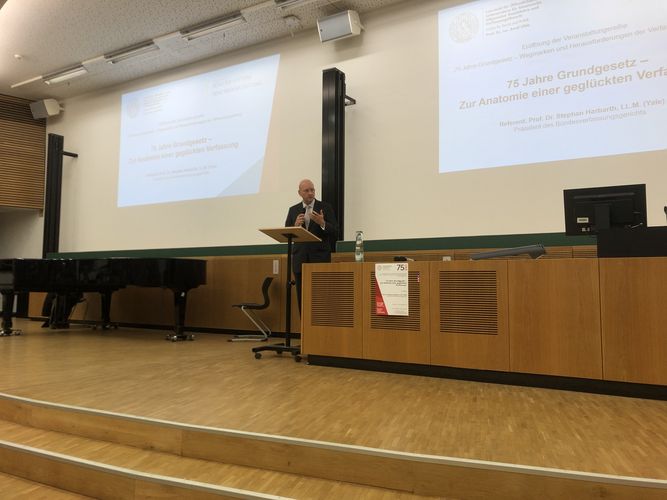 Prof. Uhle eröffnete die Veranstaltung mit einer kurzen Einführung, zu sehen auf dem Podium im Hörsaal, Foto: Jonas Frederik Hartung