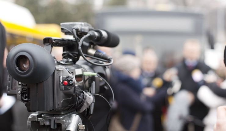 Eine Fernsehkamera vor einer Menschenmenge im Hintergrund. Der Hintergrund ist verschwommen. 