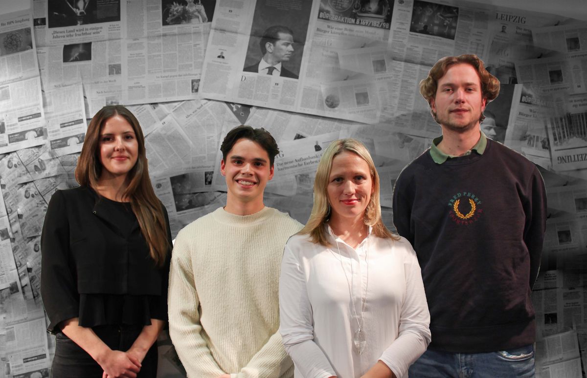Produktionsteam des Podcasts, vier Personen stehen vor einer Zeitungswand