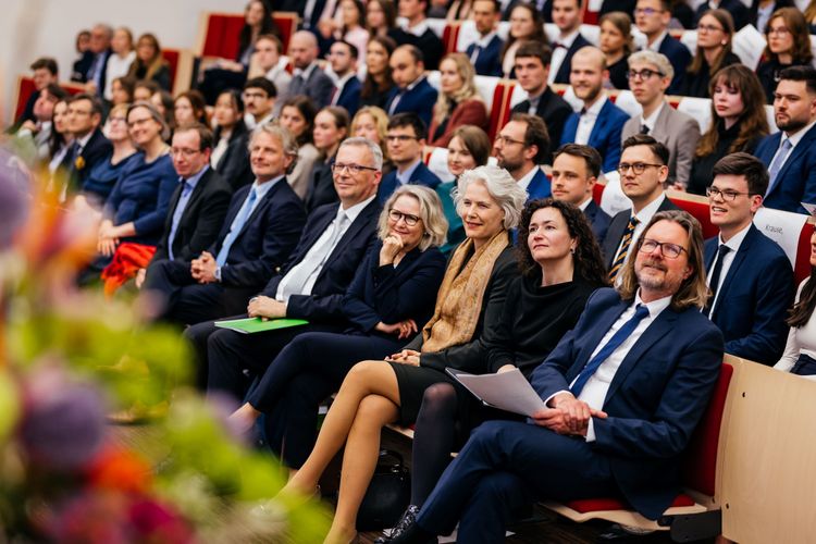 Ehrengäste und Fakultätsmitglieder drücken ihre Anerkennung für die Absolvent:innen und Preisträger:innen aus. Foto: Christian Hüller.