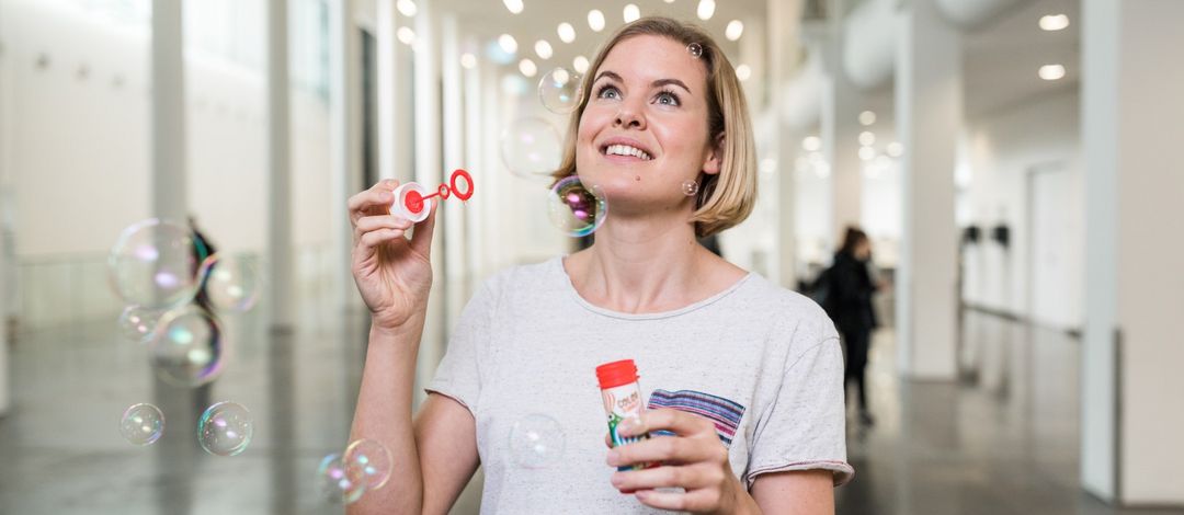 Student blowing bubbles in the Neues Augusteum.