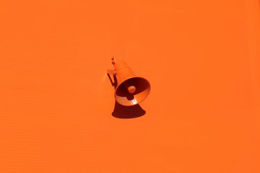 Orangener Lautsprecher auf orangener Wand