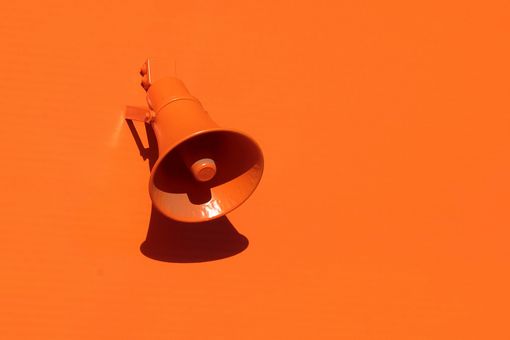 Orangener Lautsprecher auf orangener Wand