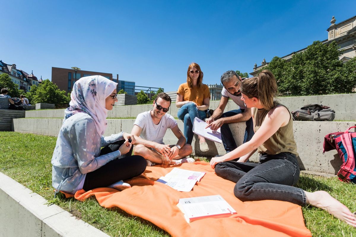 zur Vergrößerungsansicht des Bildes: Internationale Studiernde der Universität Leipzig tauschen sich auf dem sonnigen Campus aus