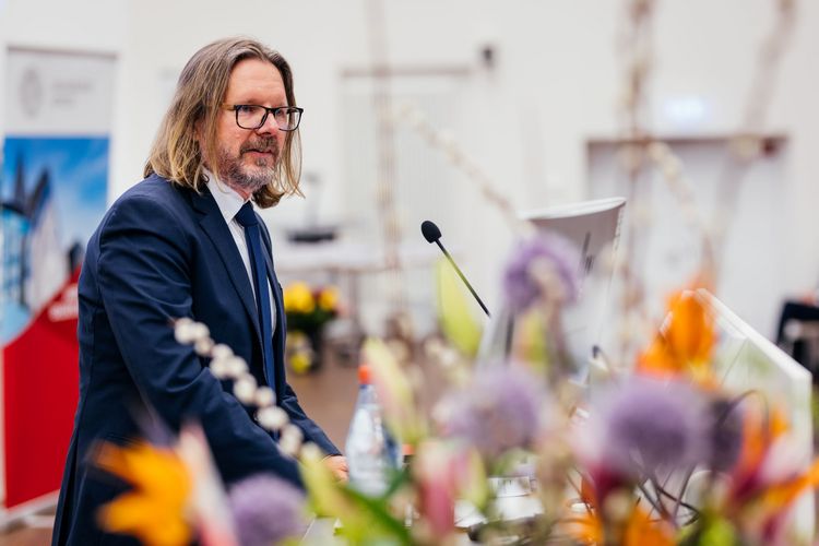 Prodekan Prof. Dr. Marc Desens begrüßt die Absolvent:innen, ihre Gäste und Ehrengäste. Foto: Christian Hüller.