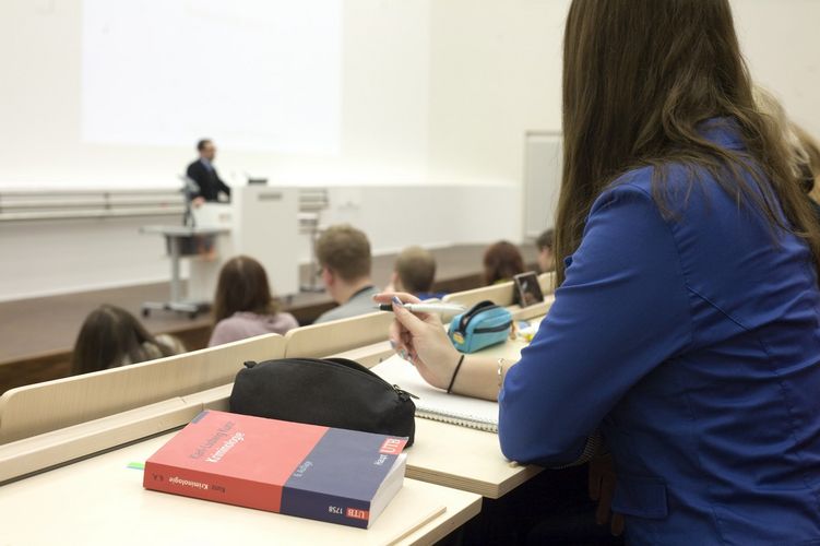 Blick auf eine Studentin, die nach vorne zur Präsentation im Hörsaal blickt, Foto: Christian Hüller 