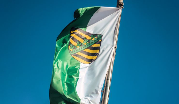 Flagge des Freistaates Sachen vor blauem Himmel
