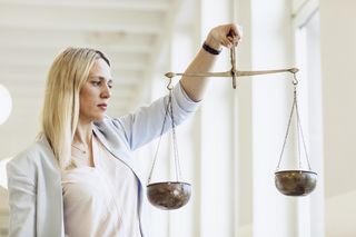 Professorin Hoven hält die Waage der Justitia im Gleichgewicht in ihrer Hand.
