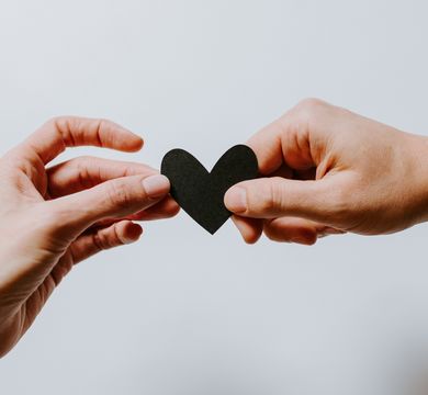 Kommunikationswissenschaften x Jura (Foto: Kelly Sikkema / Unsplash) Eine Hand reicht einer anderen Hand ein ausgeschnittenes Herz