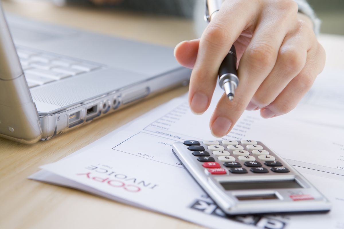 zur Vergrößerungsansicht des Bildes: Hand mit Laptop und Taschenrechner, Foto: Colourbox