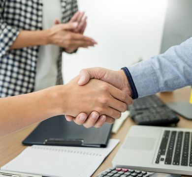 Zwei Menschen geben sich die Hand