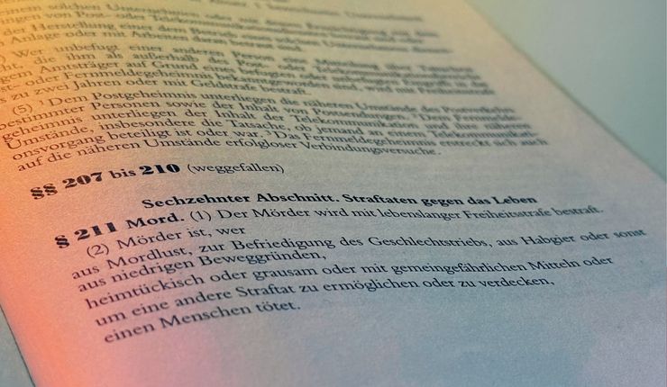 Bild eines aufgeschlagenen Strafgesetzbuches. Abgebildet ist der § 211, Mord
