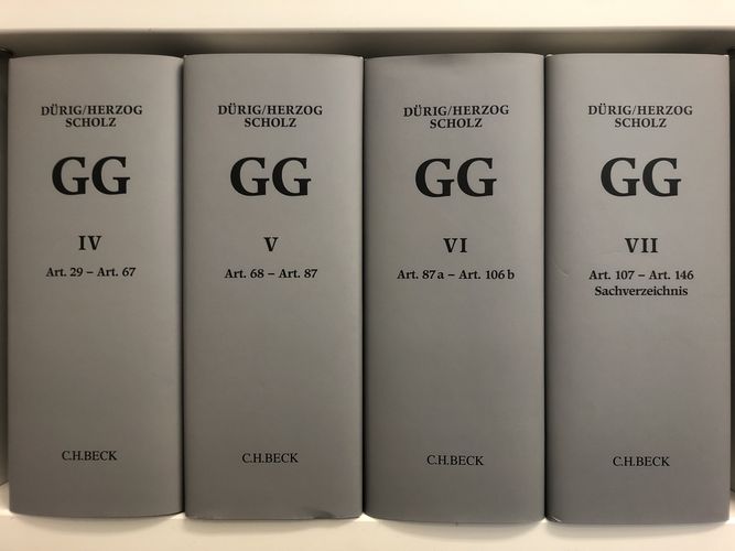 Buchrücken der Bände IV-VII des "Dürig/Herzog/Scholz" in grau, darauf in schwarzer Schrift die erwähnten Namen, darunter "GG", Bandnummer in römischer Zahl, Angabe der im jeweiligen Band enthaltenen Artikel, sowie "C.H. Beck"; Foto: Jonas Frederik Hartung 